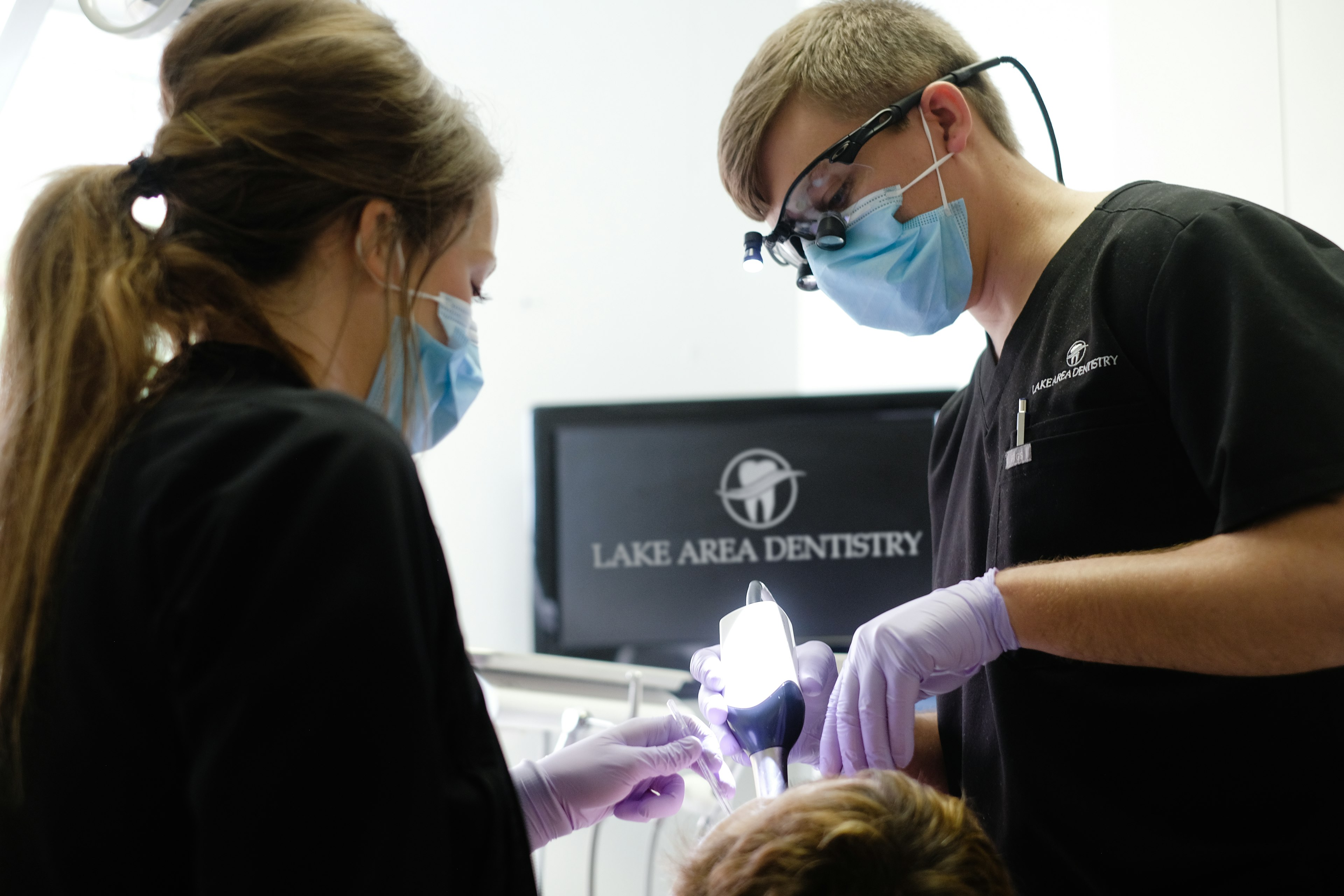 Dentist and hygienist working on patient