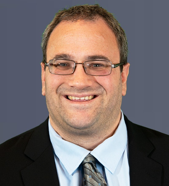 doctor with his head down and his hand on his forehead