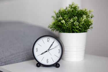 Clock on desk with plant behind