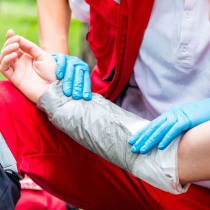 Woman bandaging construction worker's arm