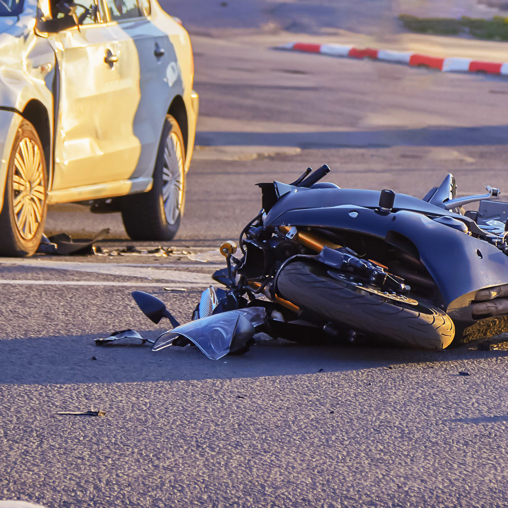 motorcycle accident with car in the background