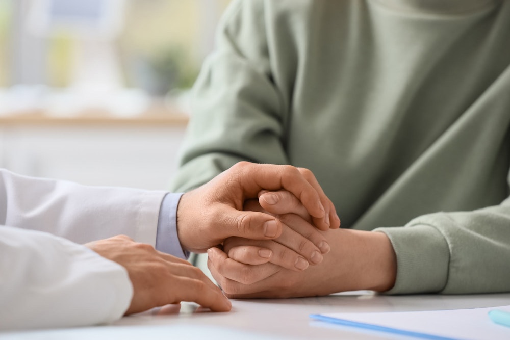 Doctor's hands comforting patient