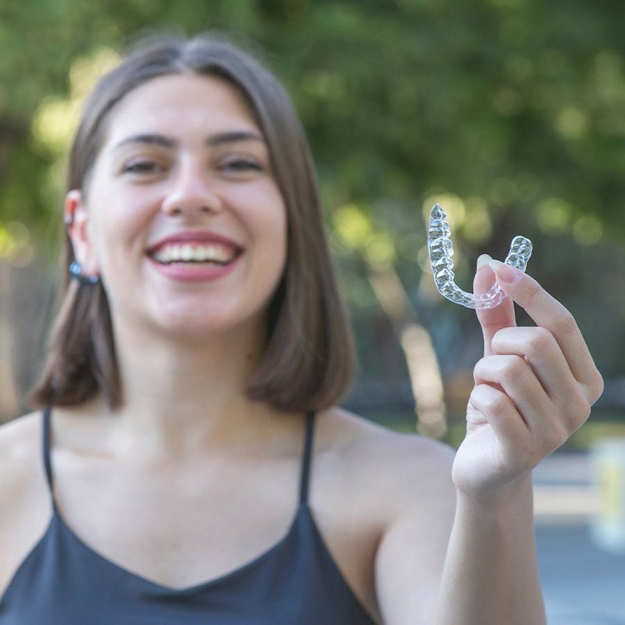 Woman holding Invisalign aligner