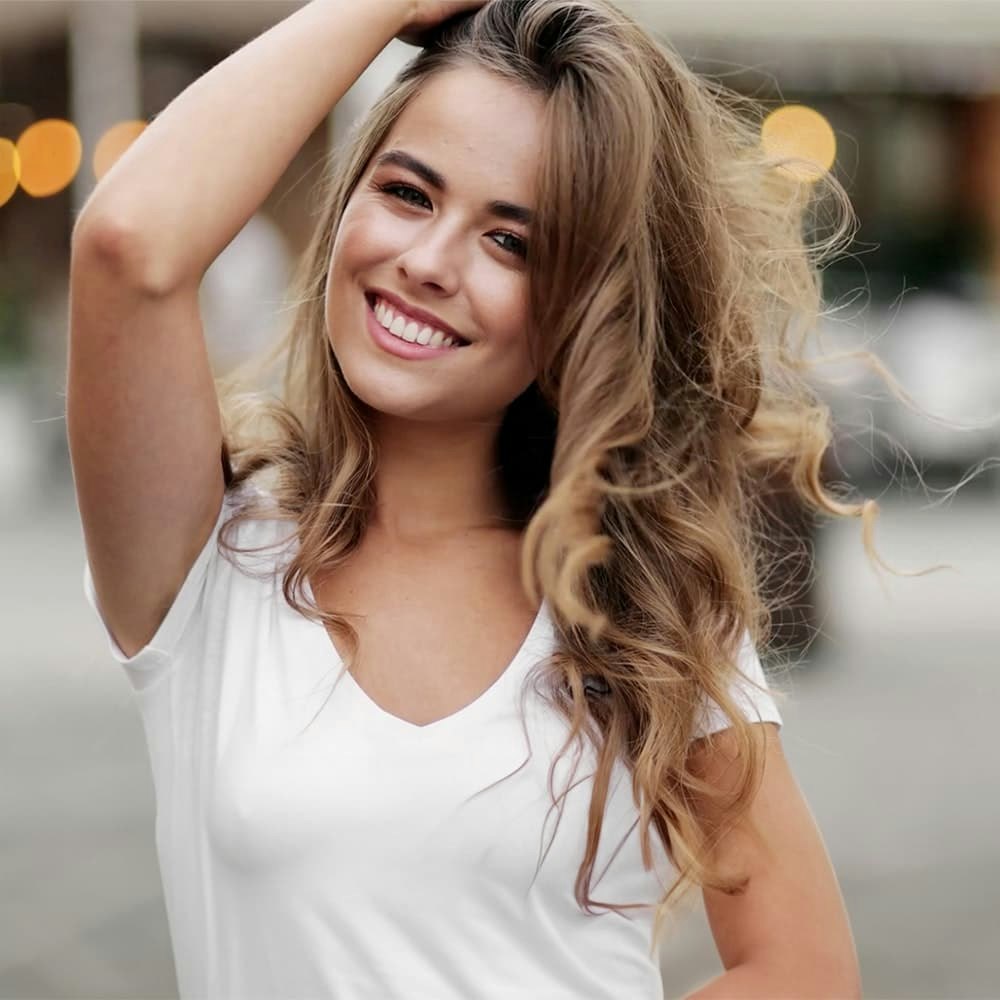 Young girl with a straight, white smile tossing her hair