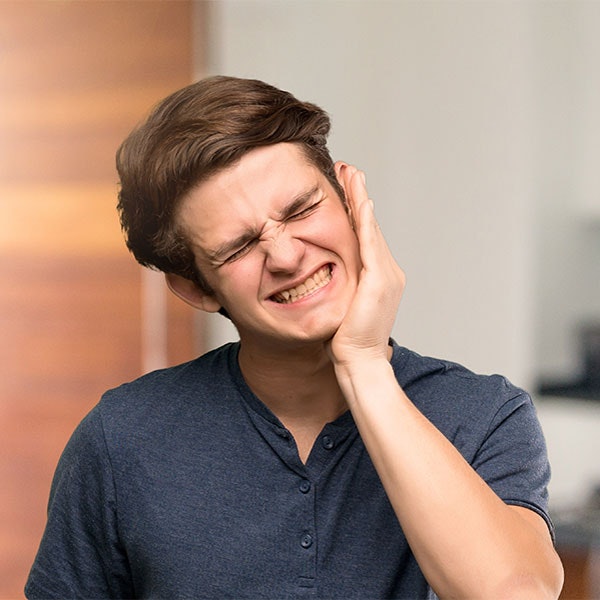 Young man in jaw pain