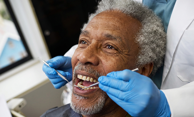 Senior man getting teeth examined