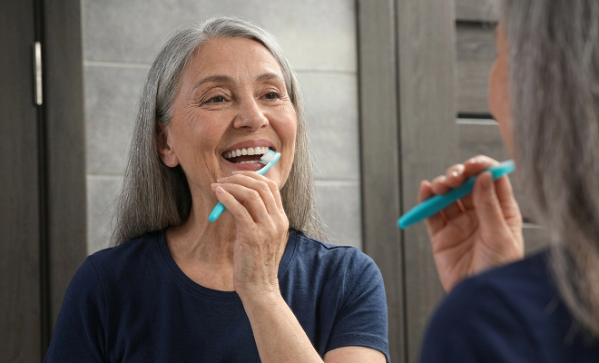 Senior woman brushing her teeth