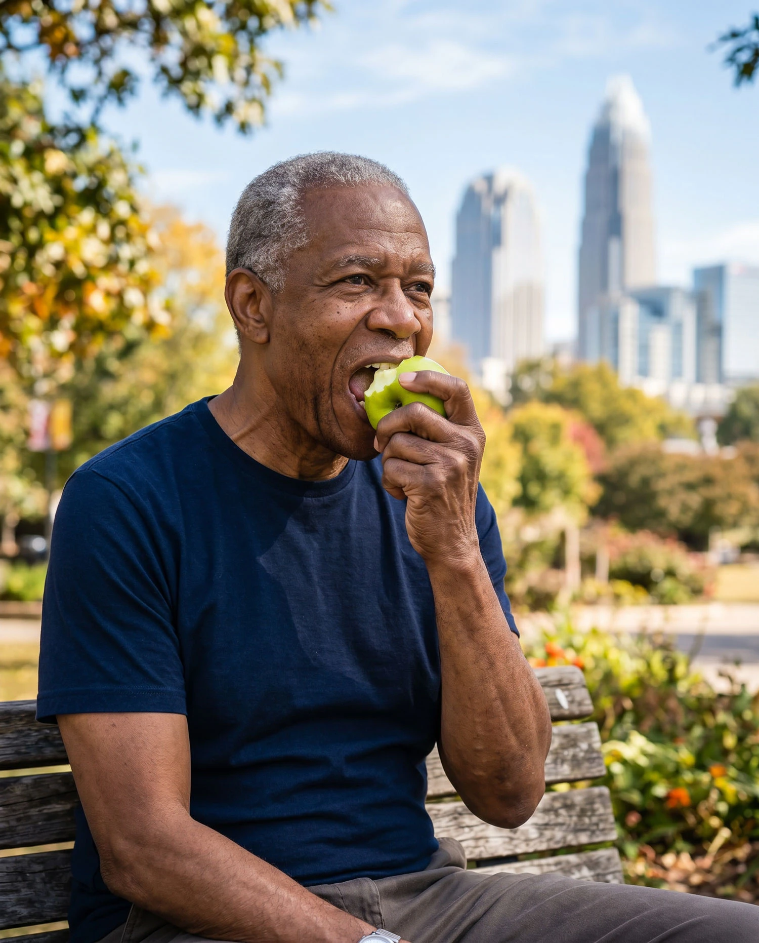 man eats an apple in the park
