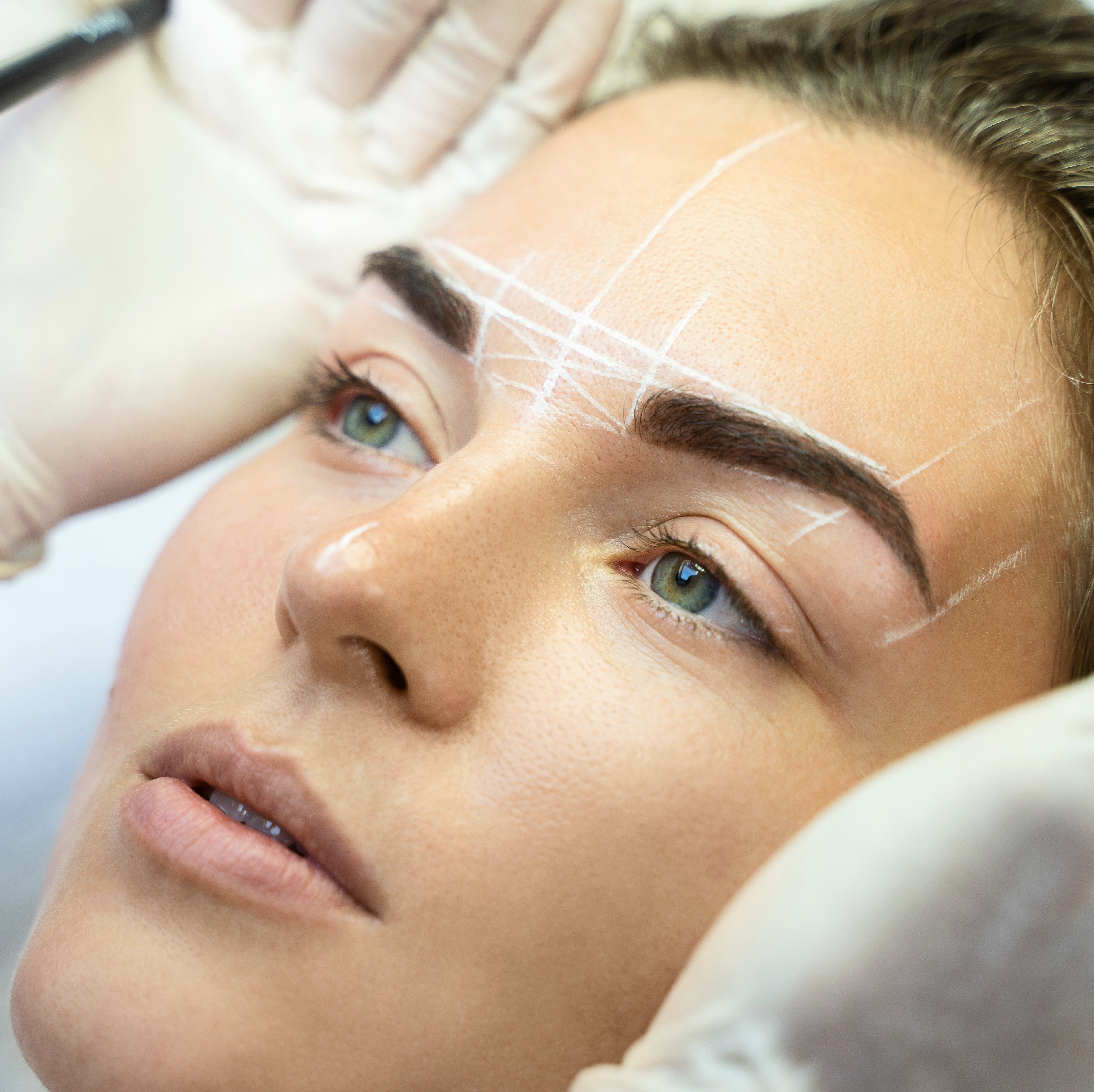 Woman having eyebrows mapped before powder shading