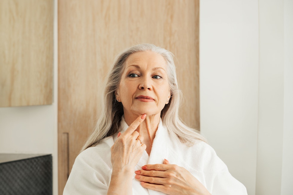 senior woman looking at her face