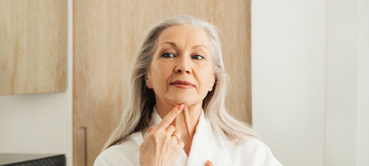 senior woman looking at her face