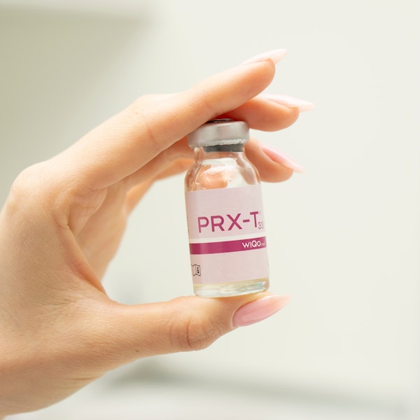Close-up of hand holding a PRX-T vial