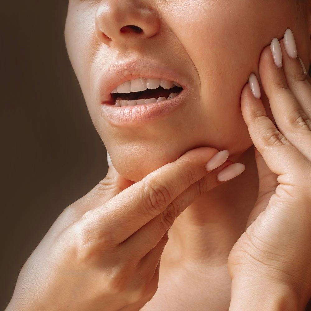 Woman holding jaw in pain