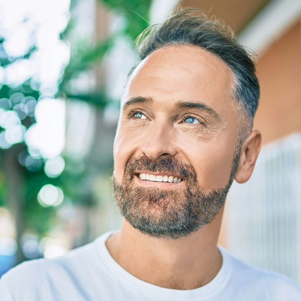 Middle aged man smiling after dental implant