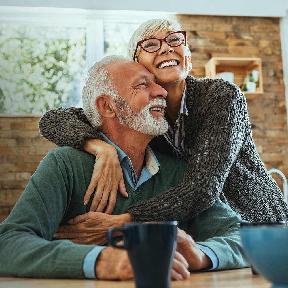 Hugging older couple with dentures