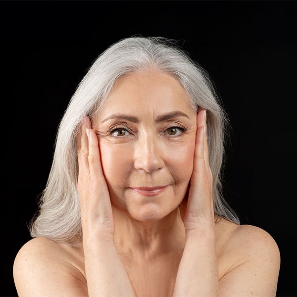 Close up of older woman's face with very few wrinkles