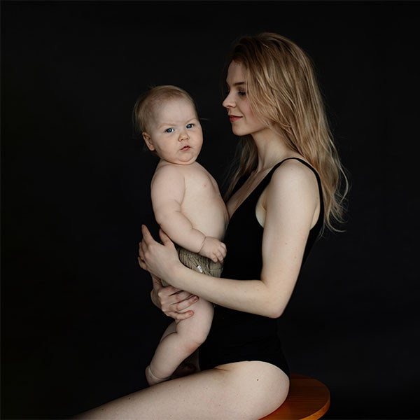 Mother sitting on stool holding baby