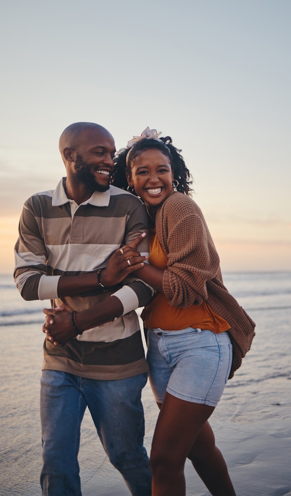 Couple smiling and walking down beach