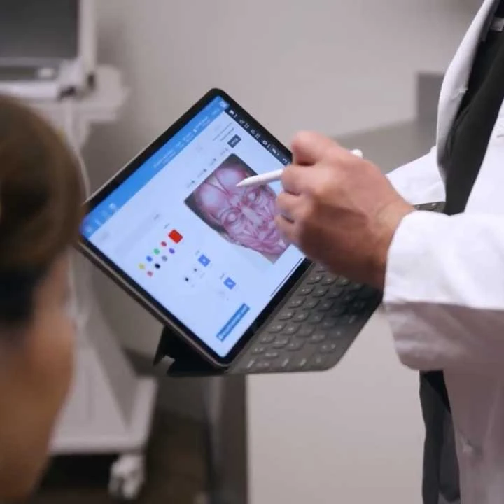 Dr. Michael Devlin with patient reviewing facial procedure plan