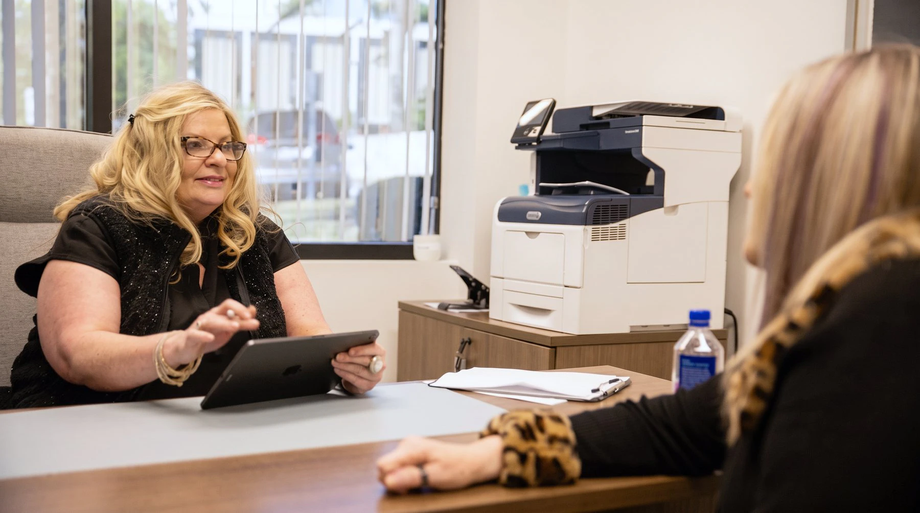 A patient coordinator reviews financing options with a patient at Devlin Cosmetic Surgery