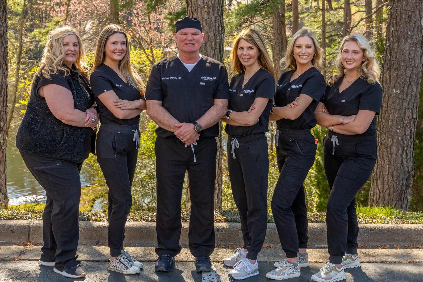 Dr. Devlin and his Little Rock cosmetic surgery team outdoors among the pines
