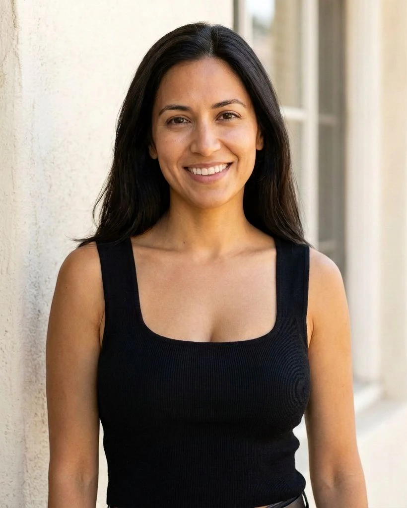 A smiling woman with long dark hair in a black square-neck top