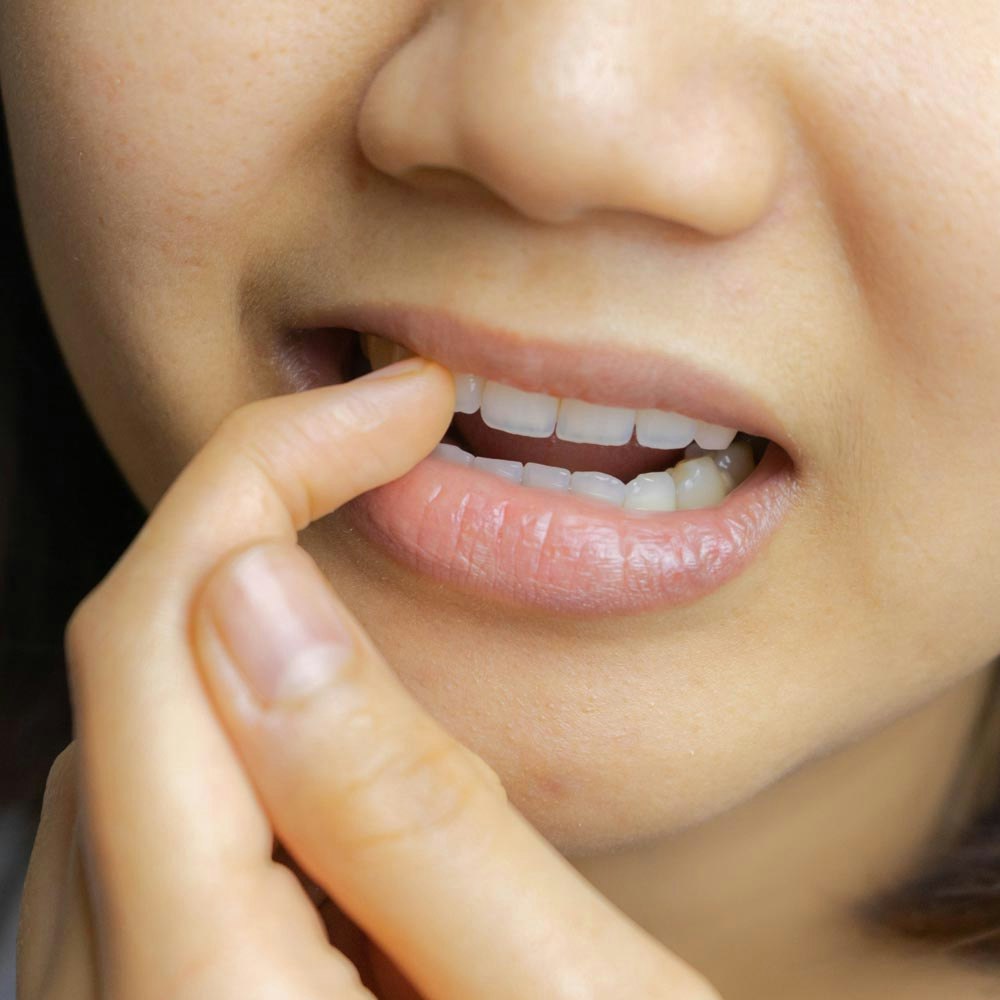 Concerned woman pointing at her teeth