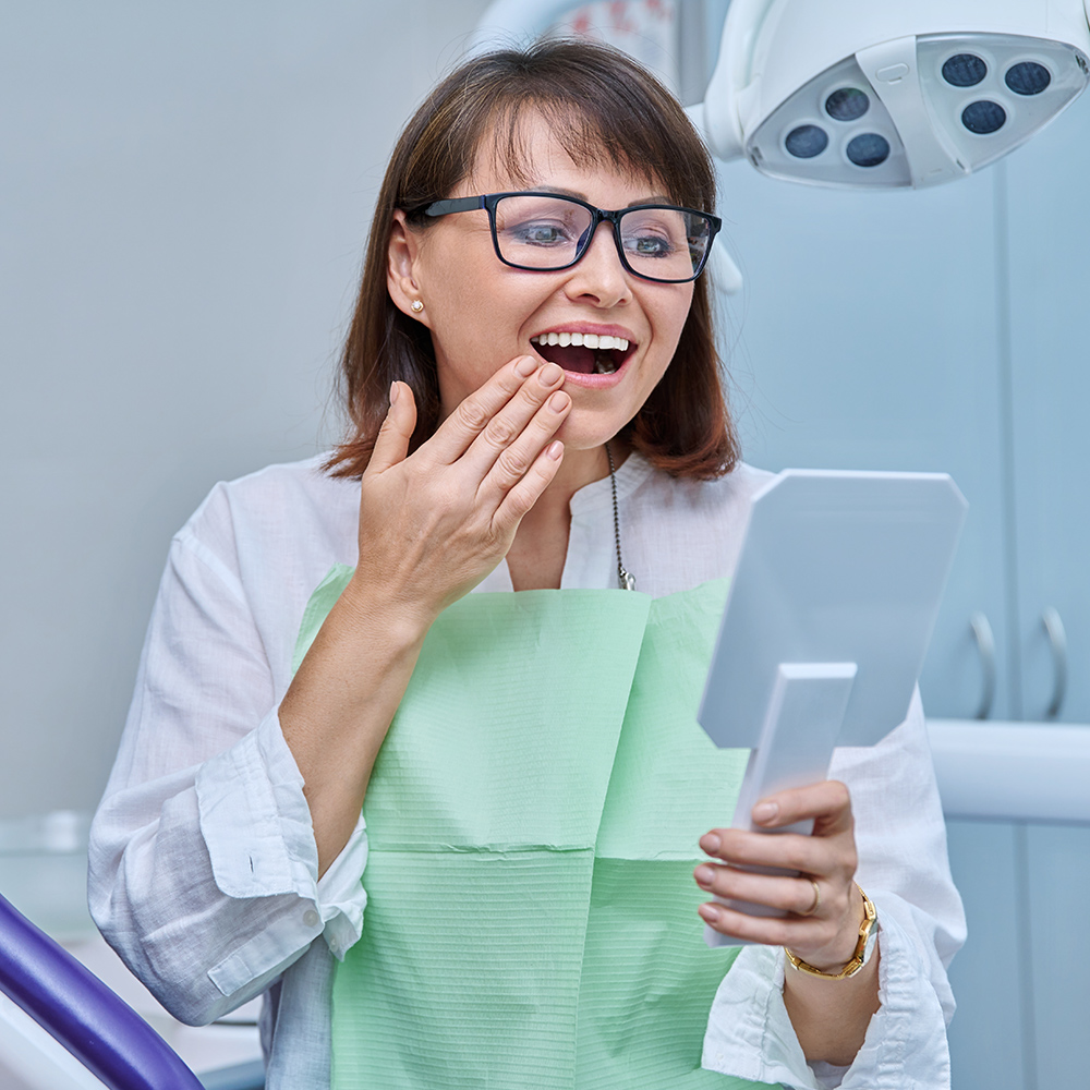 a woman looking at her teeth in a mirror