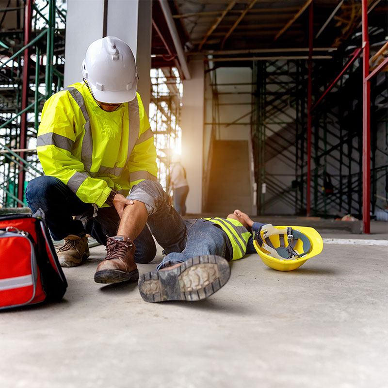 Man helping another who is injured on a construction site