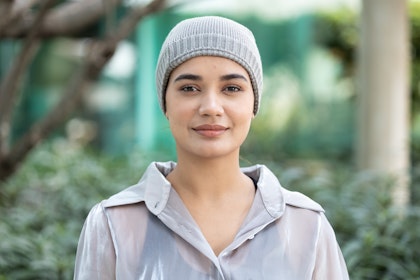 Cancer survivor wearing a beanie and slightly smiling