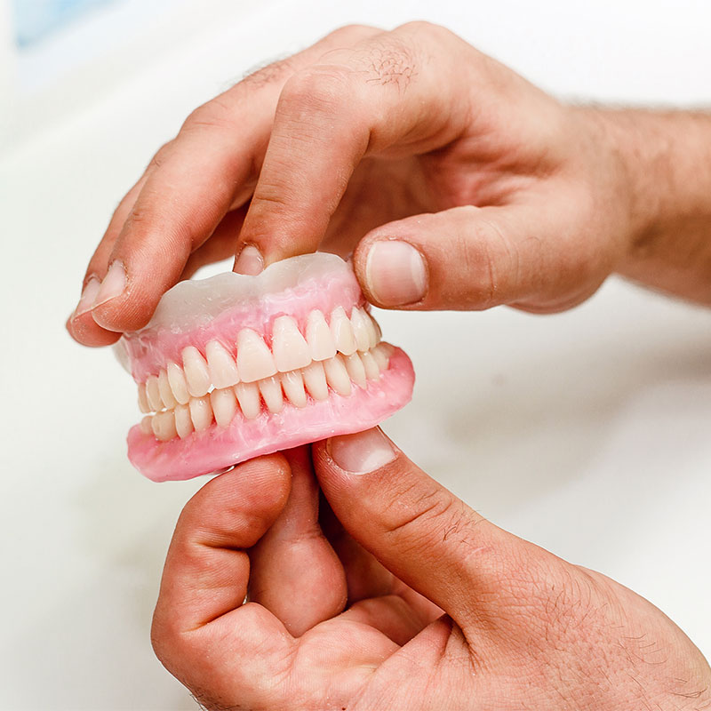 Person holding full dentures