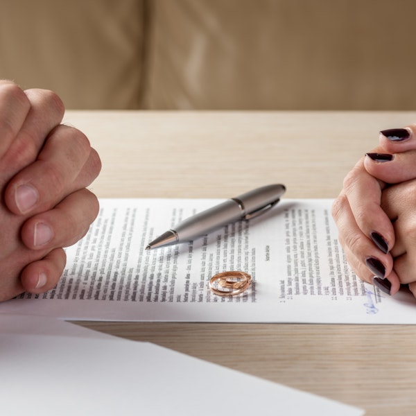 contract with wedding rings and couple's hands