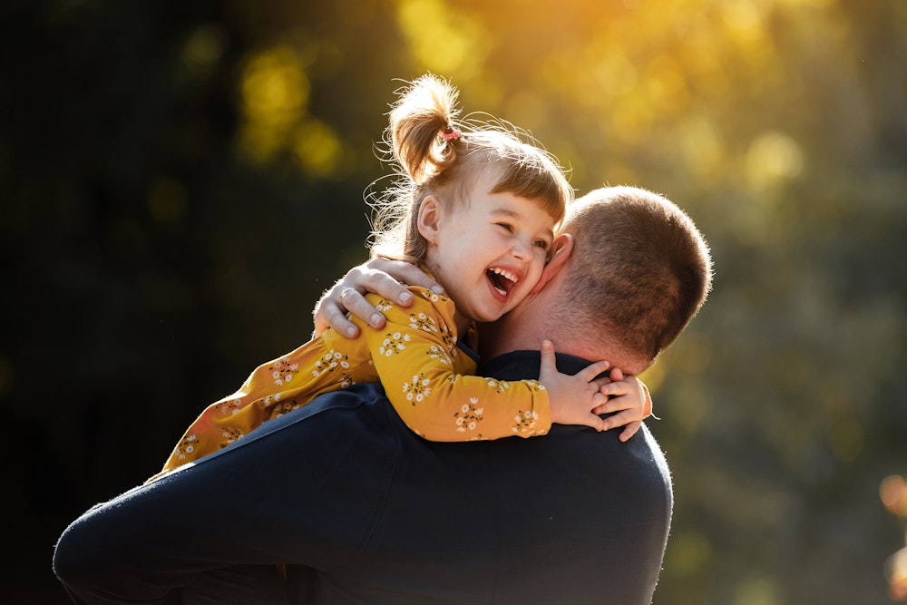 A father and young daughter hugging