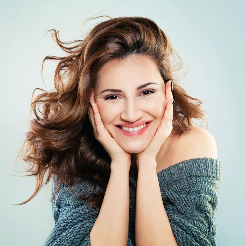 Smiling woman resting face on hands