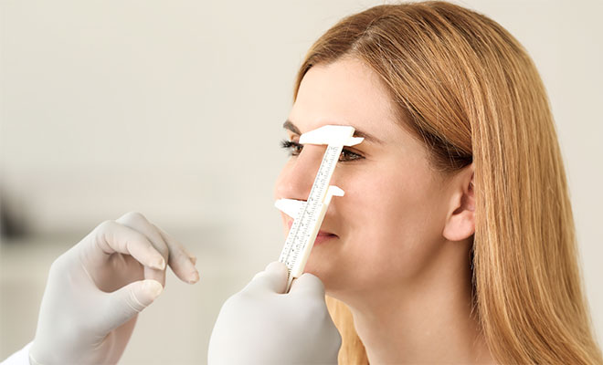 Doctor measuring their patient's nose