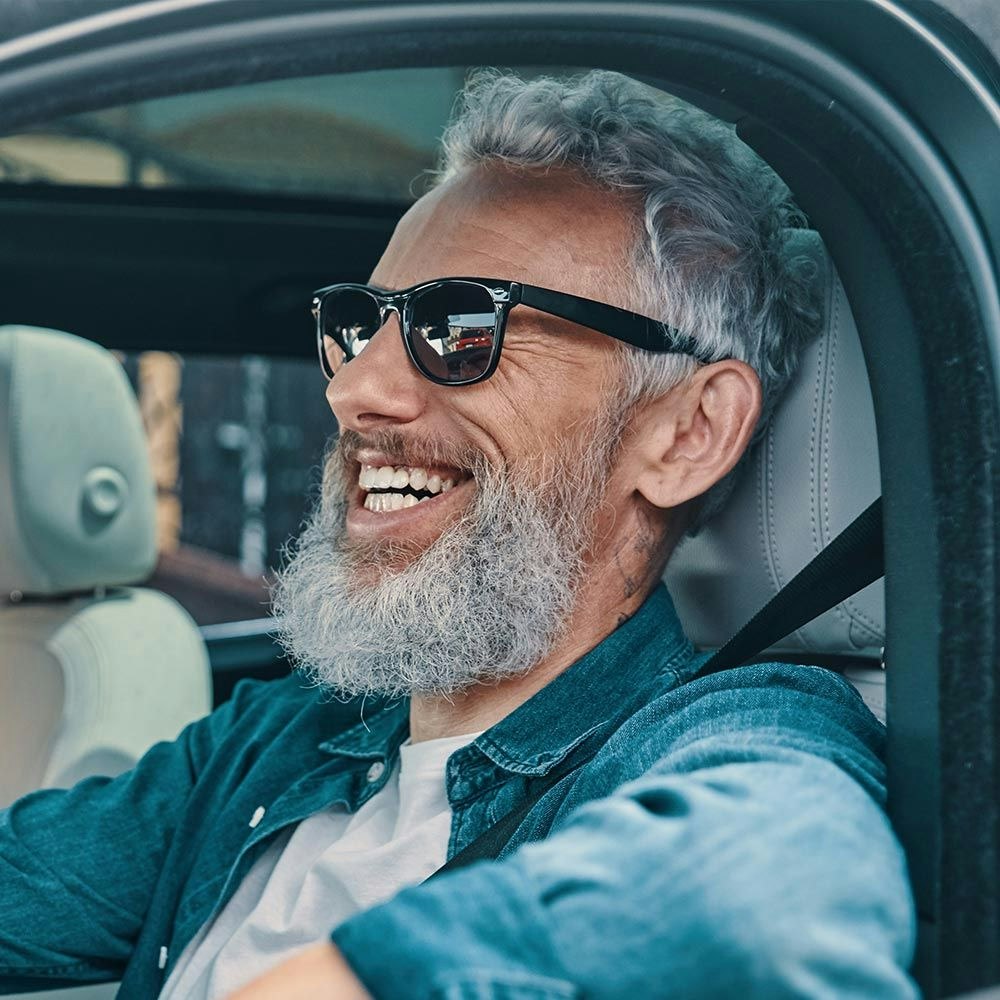 Older man smiling while driving