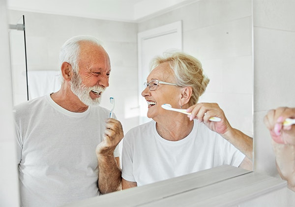 mature couple brushing teeth together