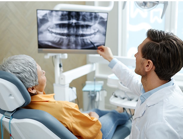 dentist and patient examining x-rays