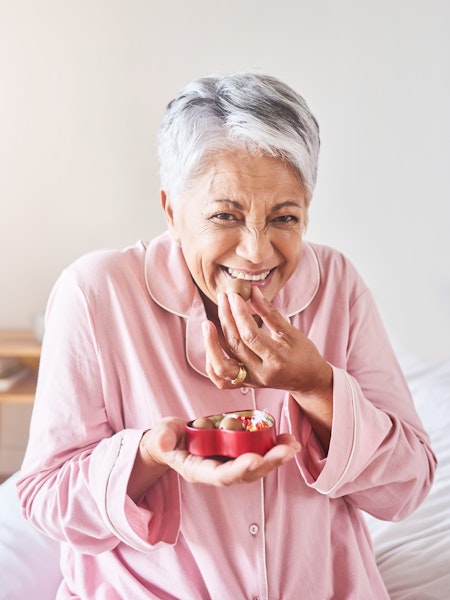 Elderly woman eating candy