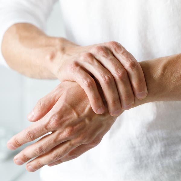 man holds hand in pain