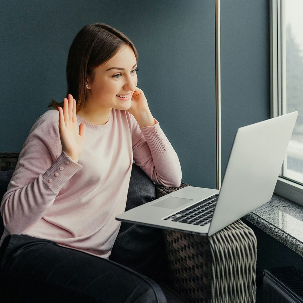 Young woman waving to Dr. Lowe on laptop