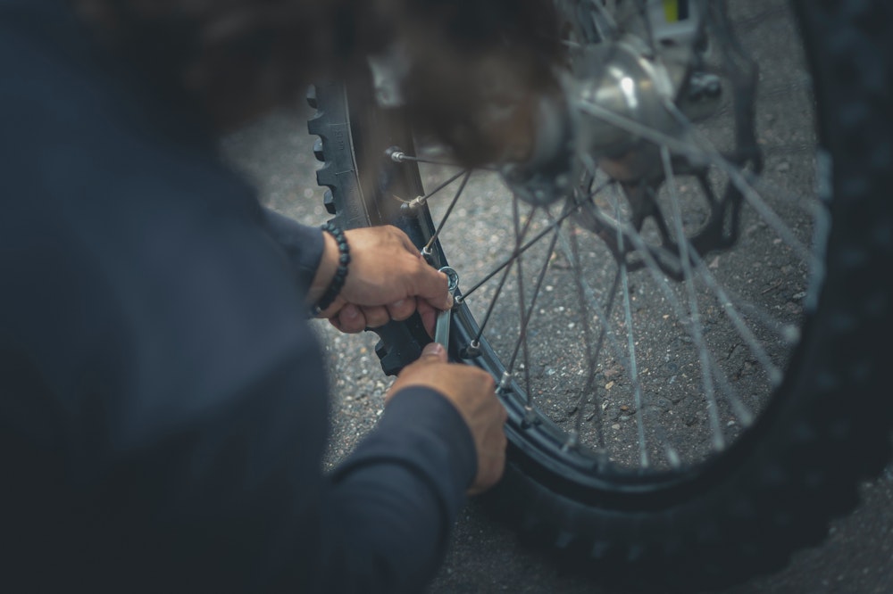 Person working on bike wheel