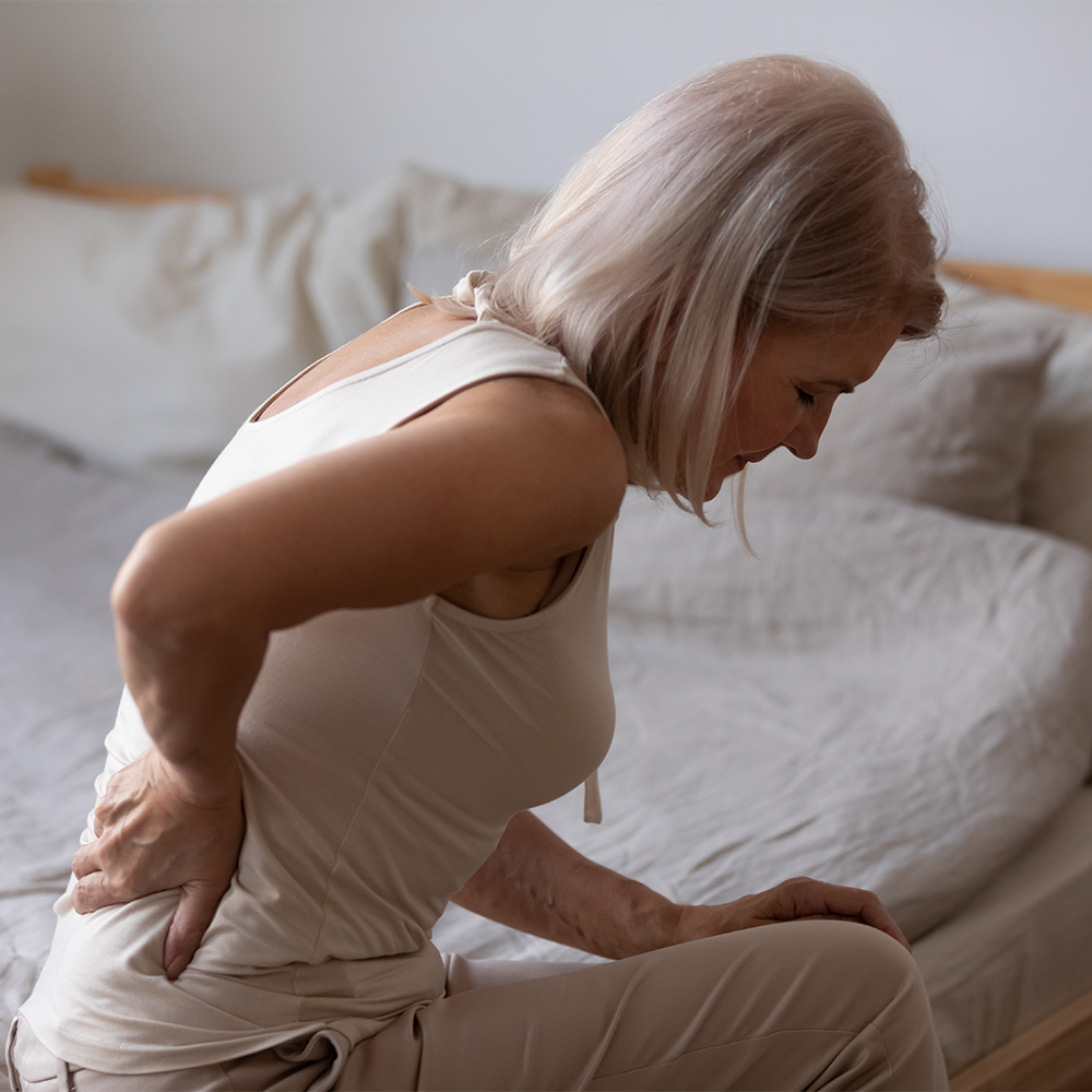 woman holding lower back in pain