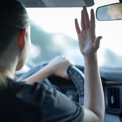 Woman driver throwing her hands up in anger