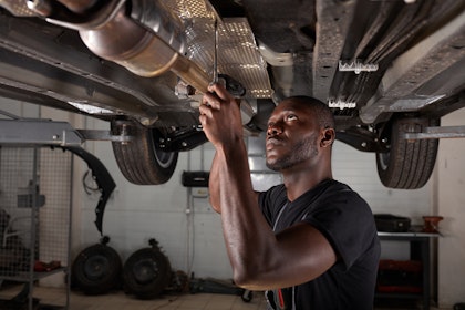 Mechanic working on the underside of a vehicle