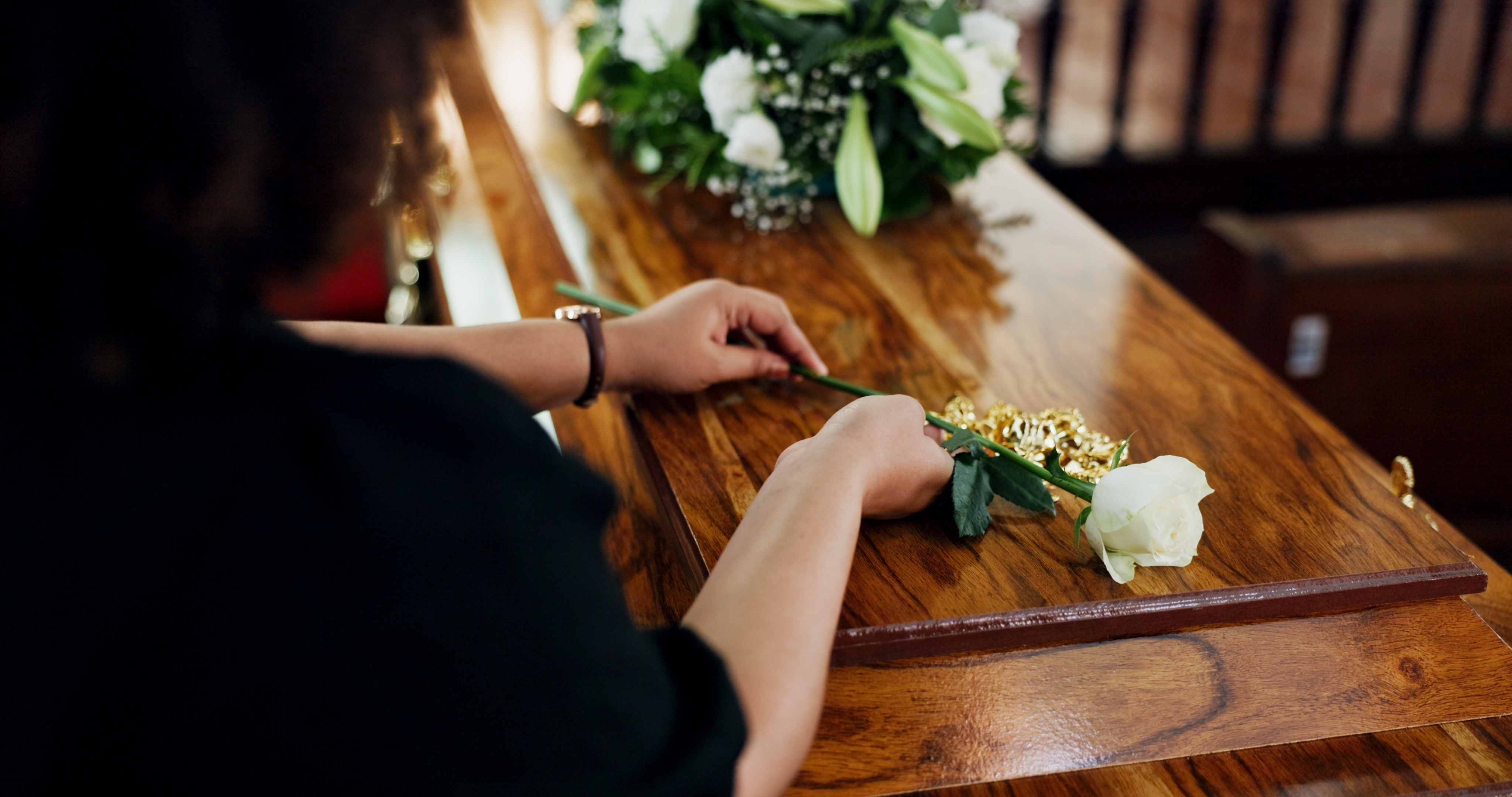 Woman placing rose on casket