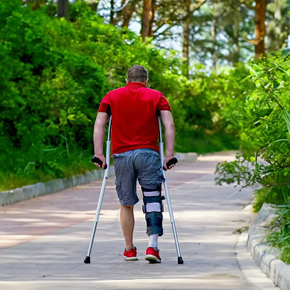 Man walking in a brace with crutches