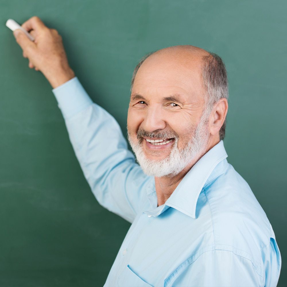 Smiling man standing in front of chalkboard