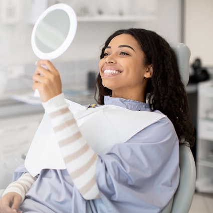 Smiling patient looking in mirror after Cosmetic Dentistry