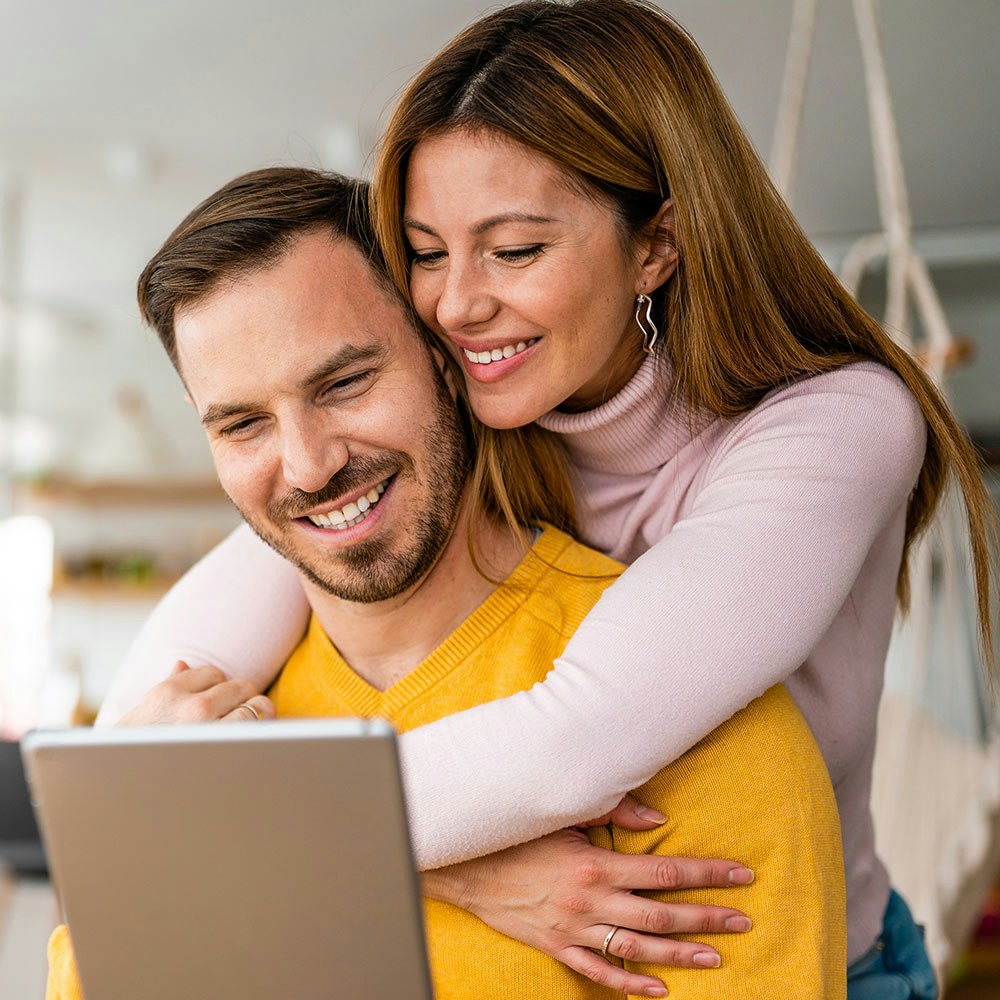 Couple smiling and looking at tablet